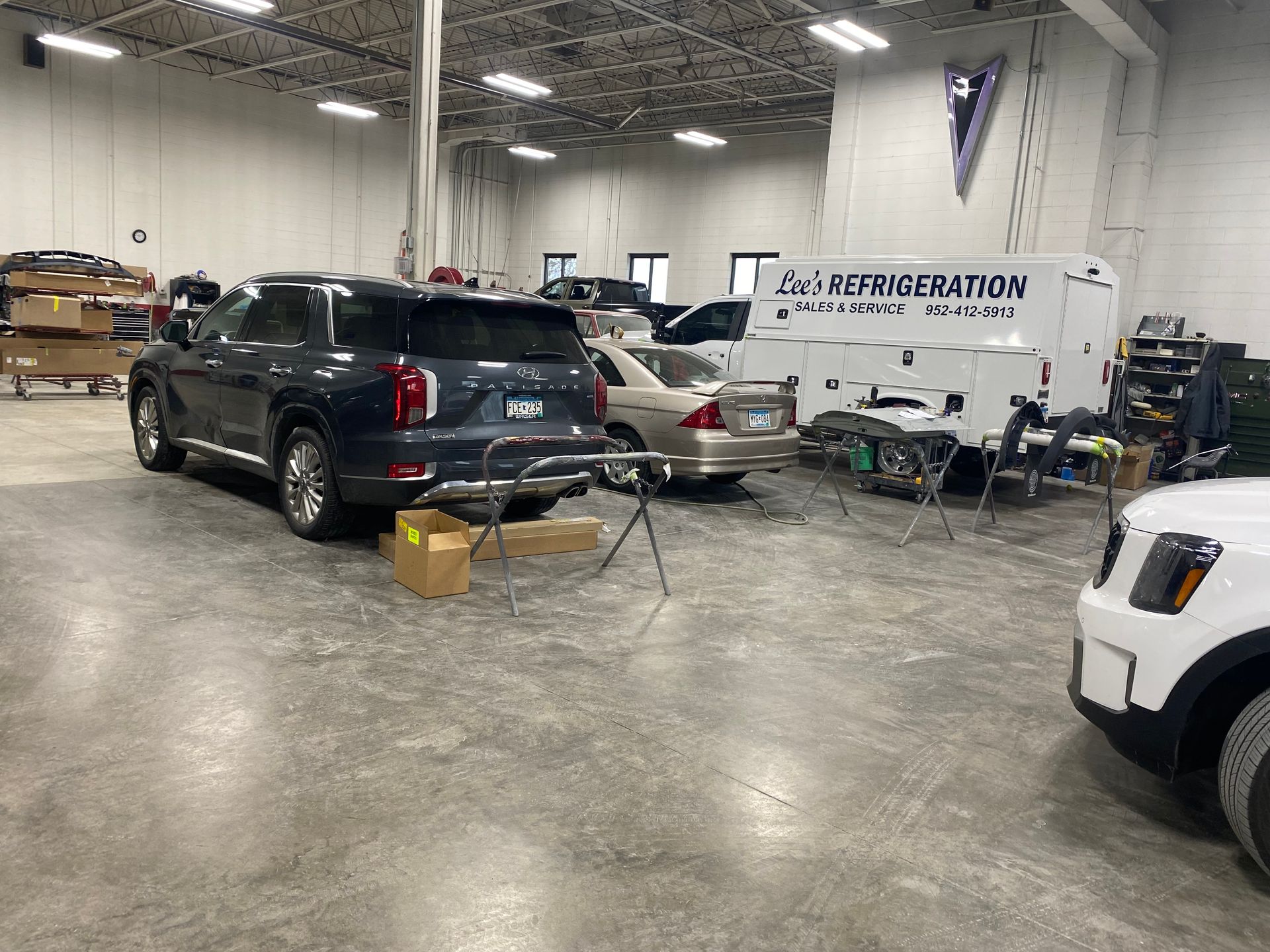 A black suv is parked in a garage next to a white van.