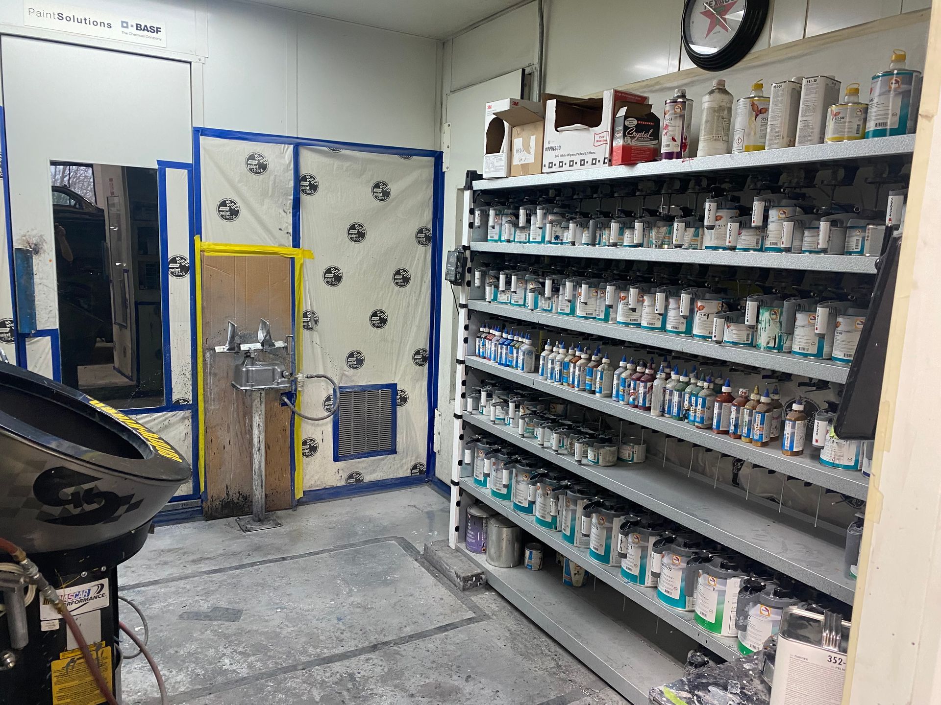 A room filled with shelves filled with bottles of paint.