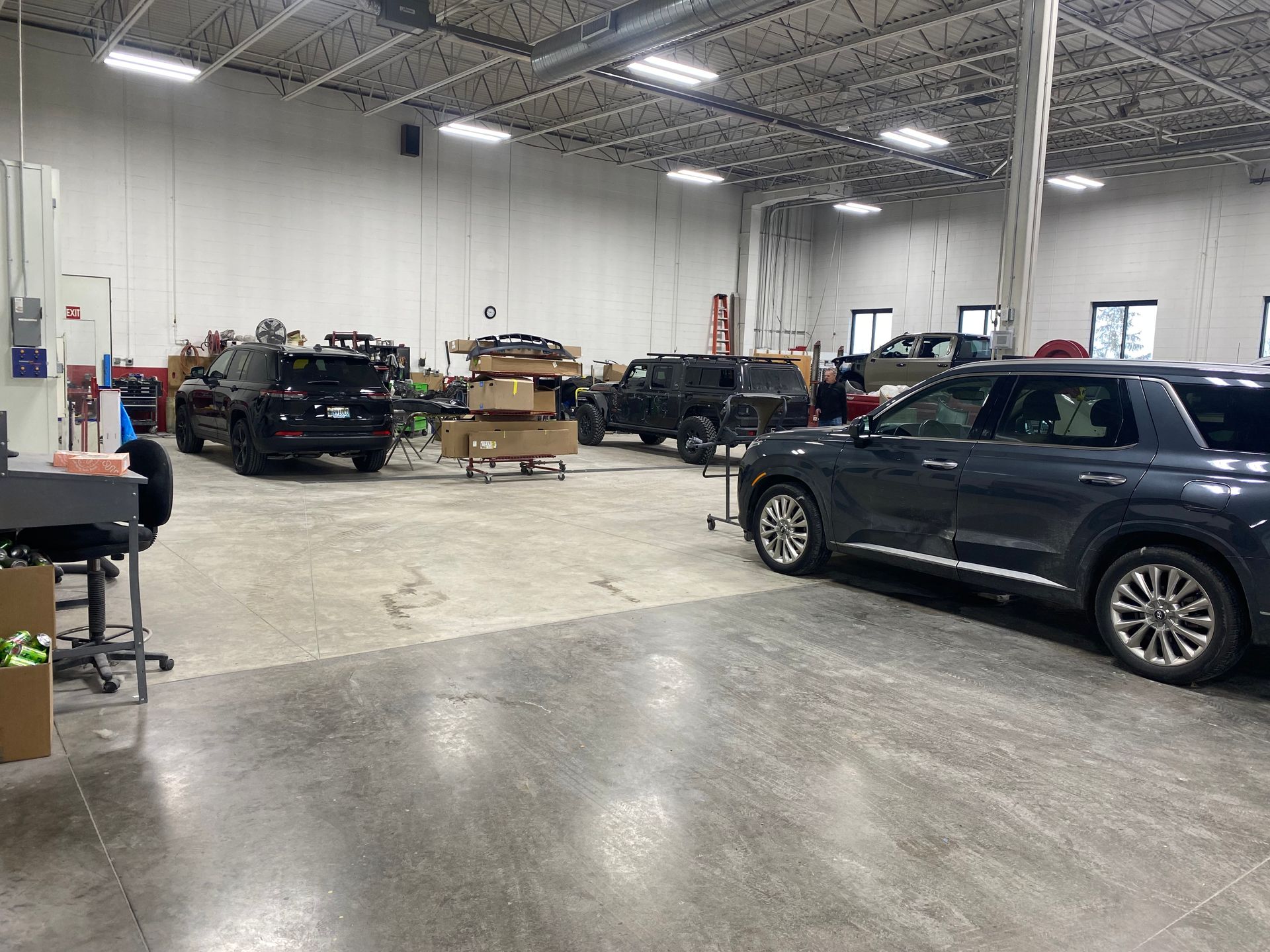 A large warehouse with a lot of cars parked in it.