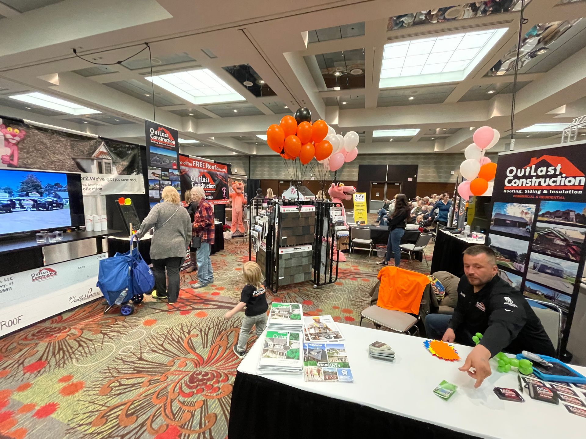 A group of people are standing around a table at a convention.