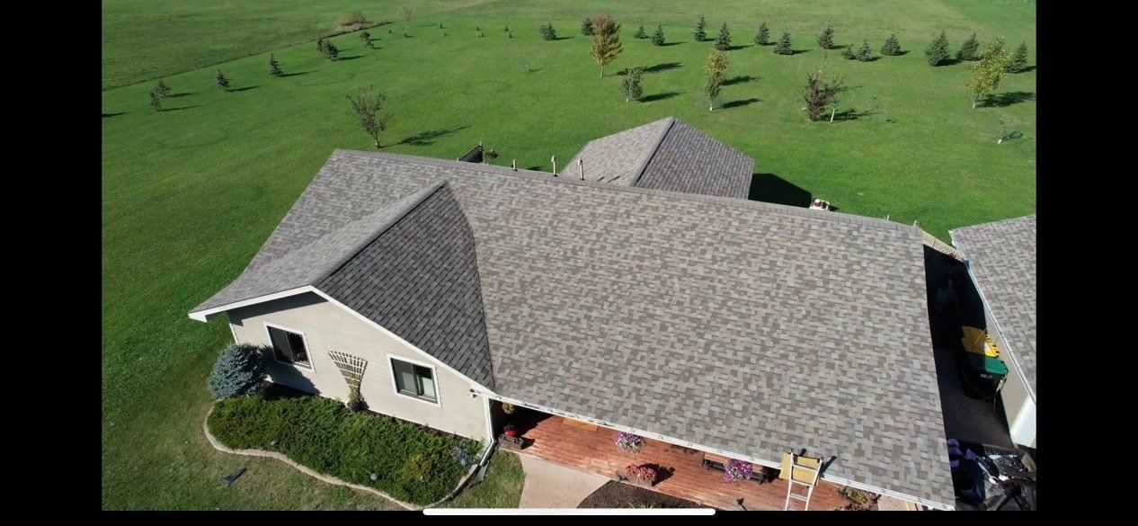 An aerial view of a house with a group of people standing in front of it.