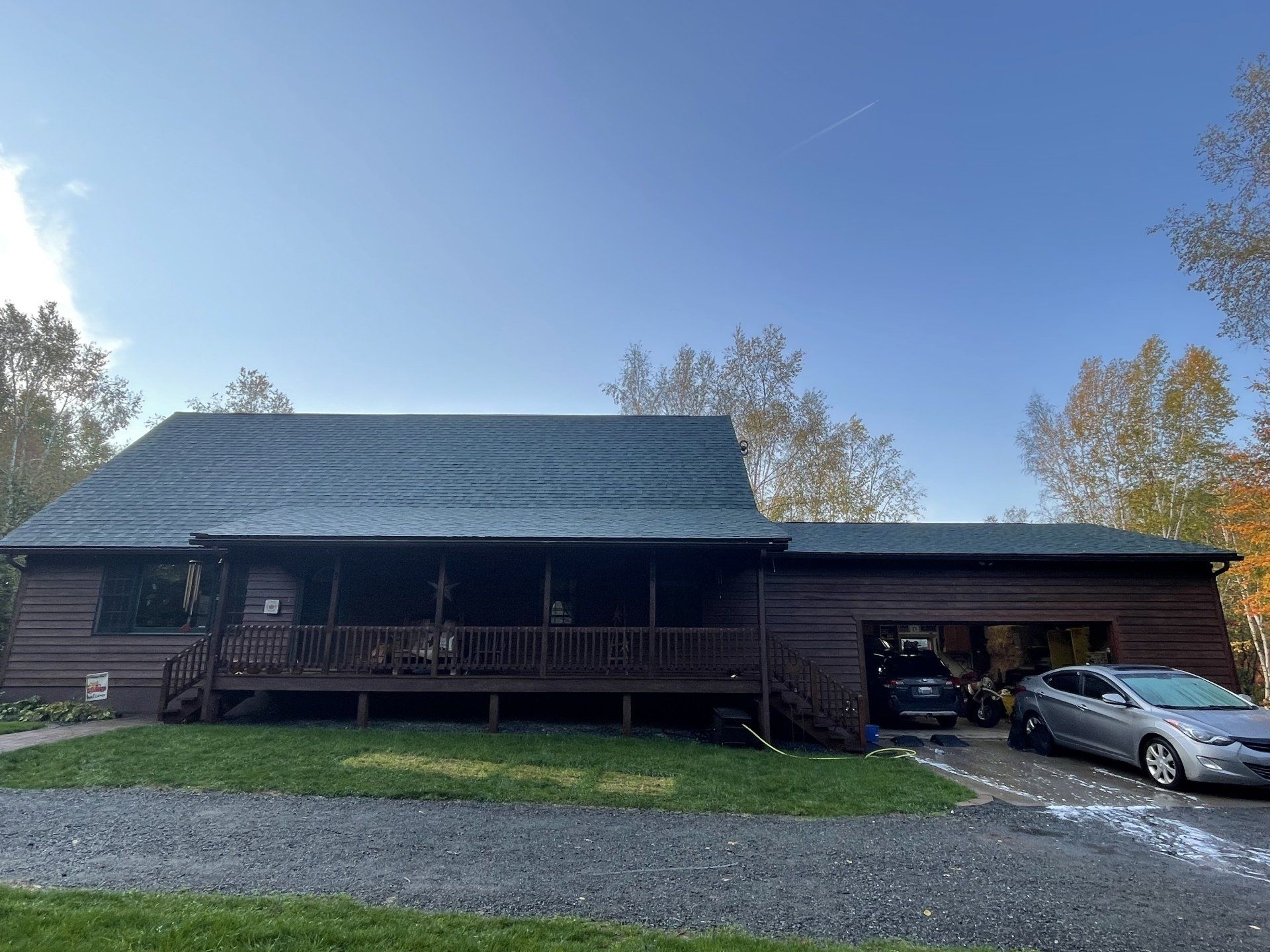 A large log cabin with a car parked in front of it.