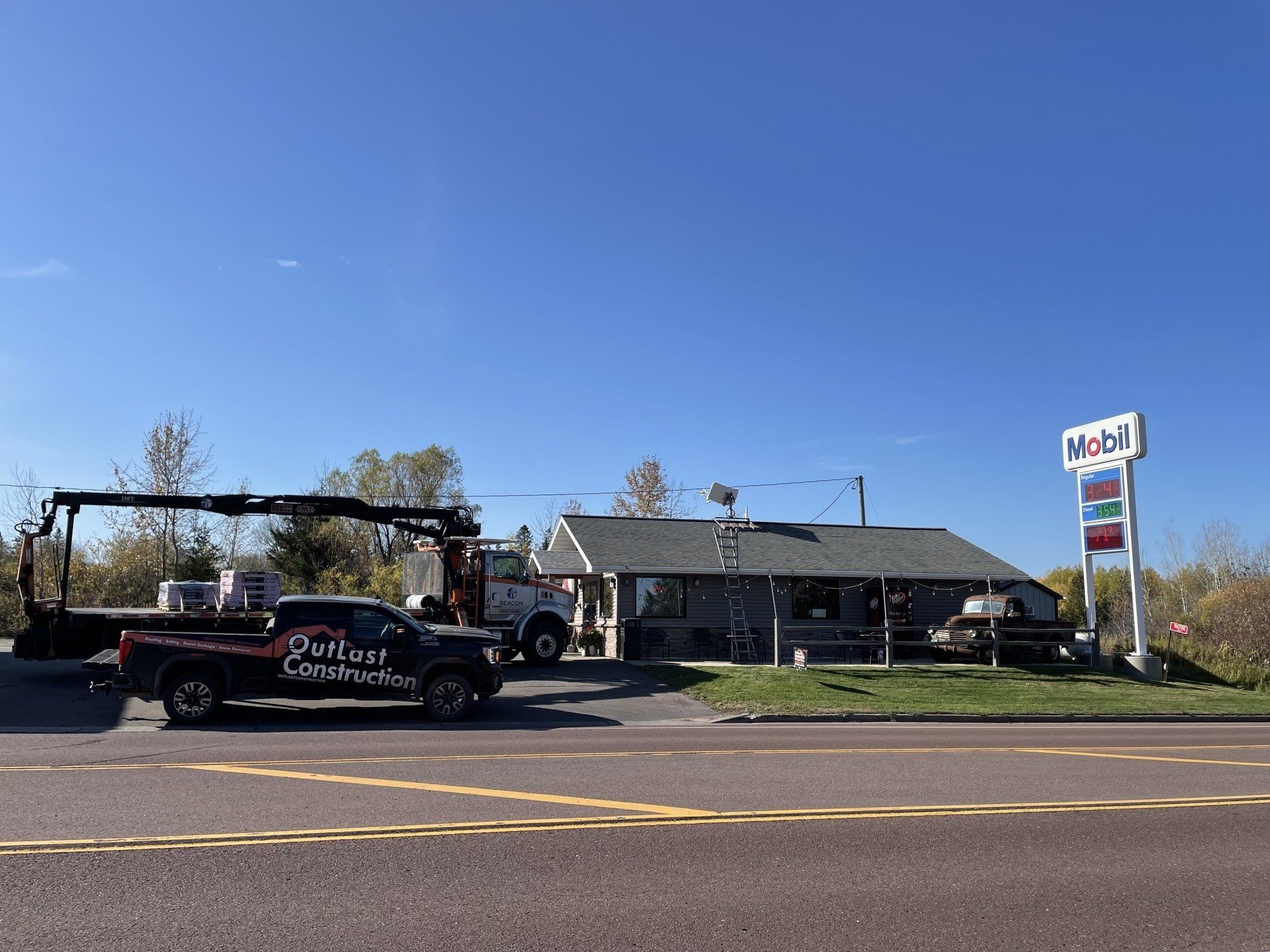 A tow truck is parked in front of a gas station.