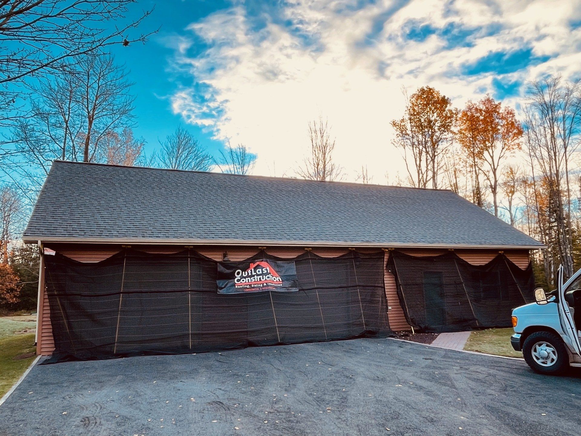 A truck is parked in front of a garage door that is open.
