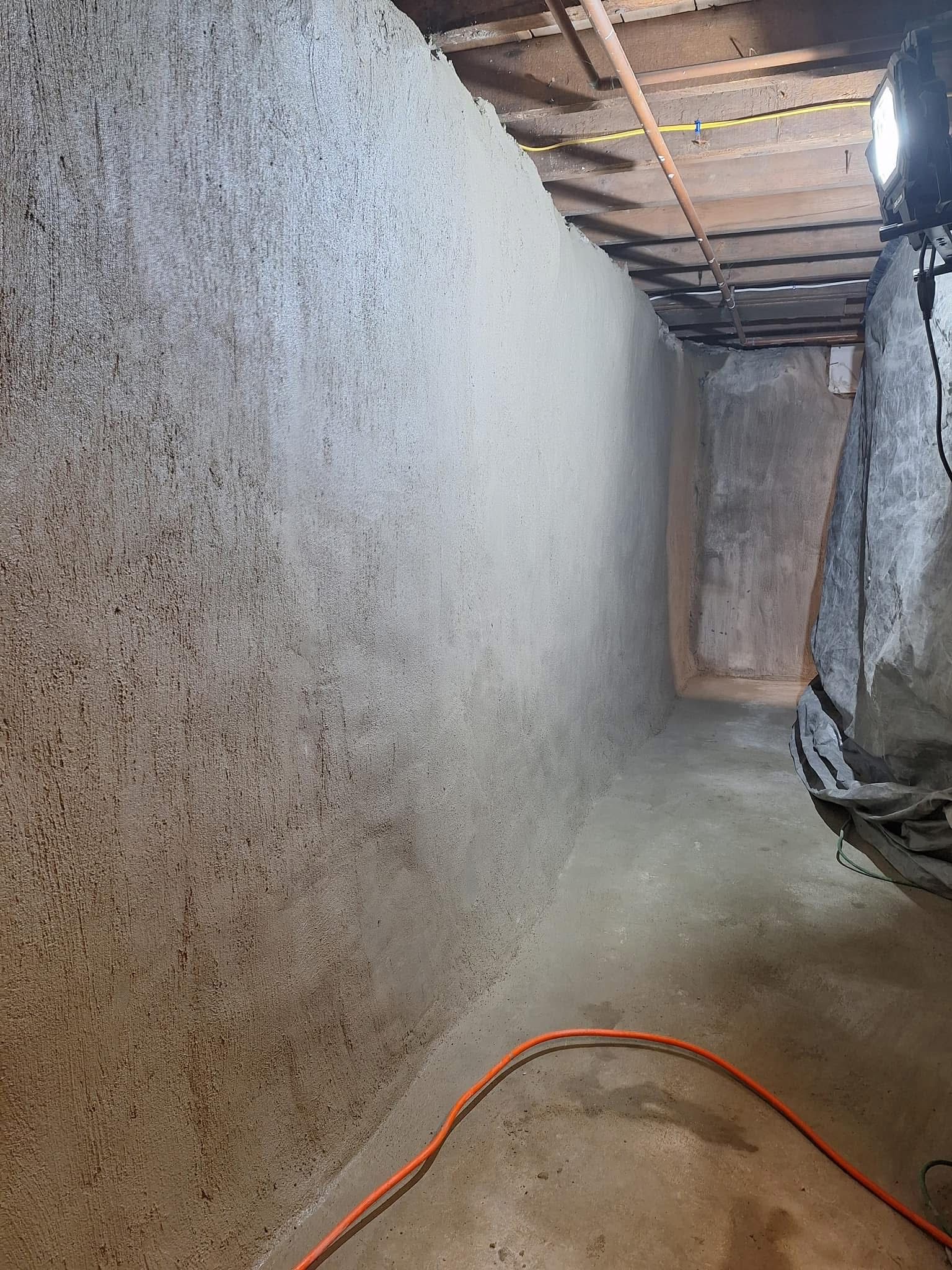 Interior of a basement with spray-foam insulation on walls.