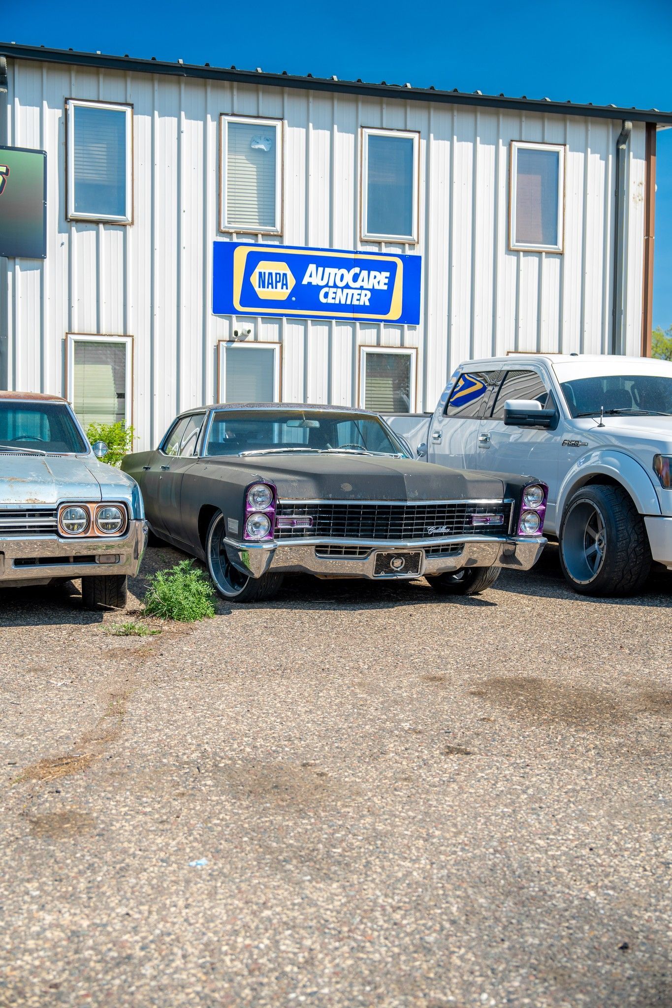 Cars parked in front of an auto shop with an 