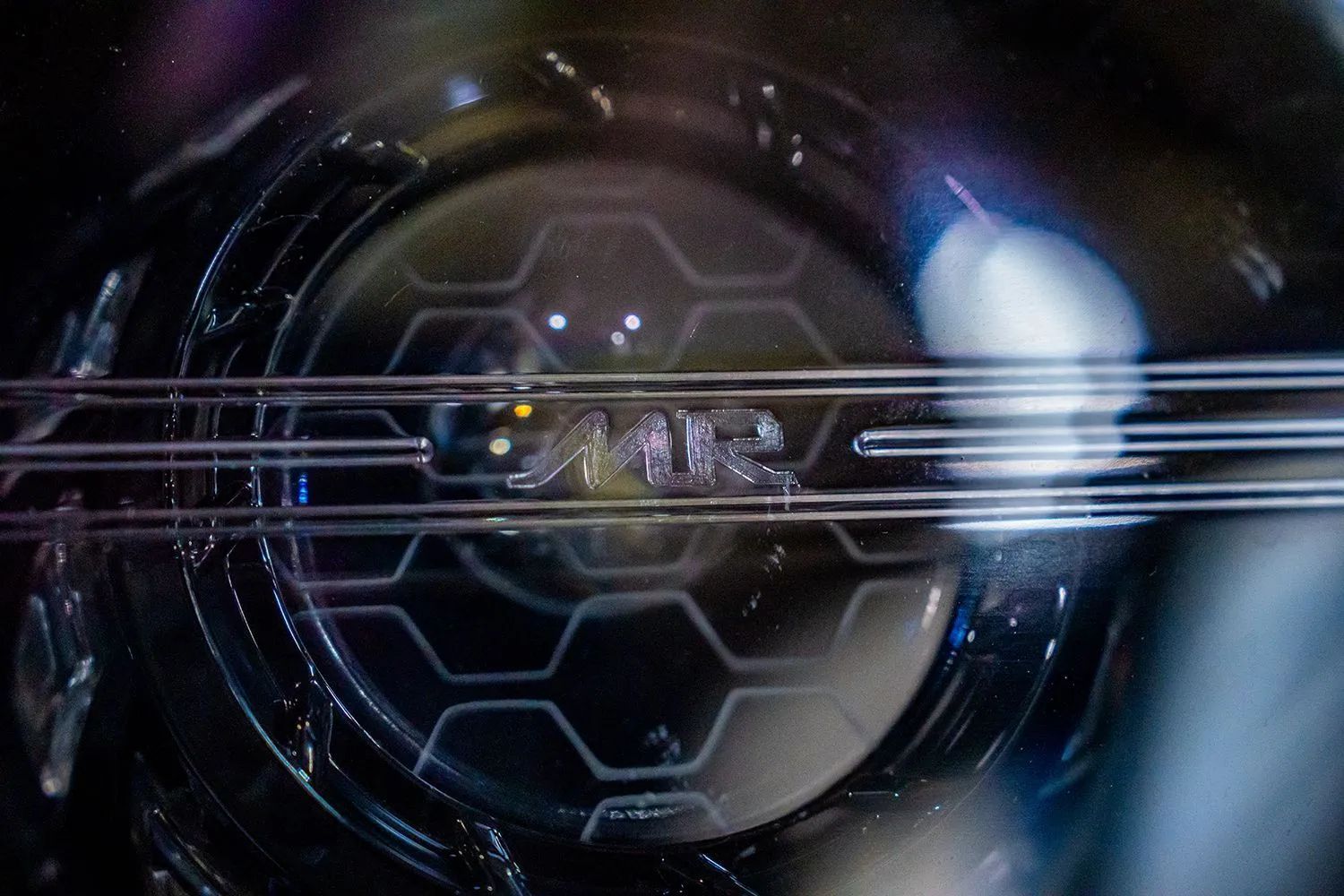 Close-up of a clear, circular object with a honeycomb pattern and the letters 