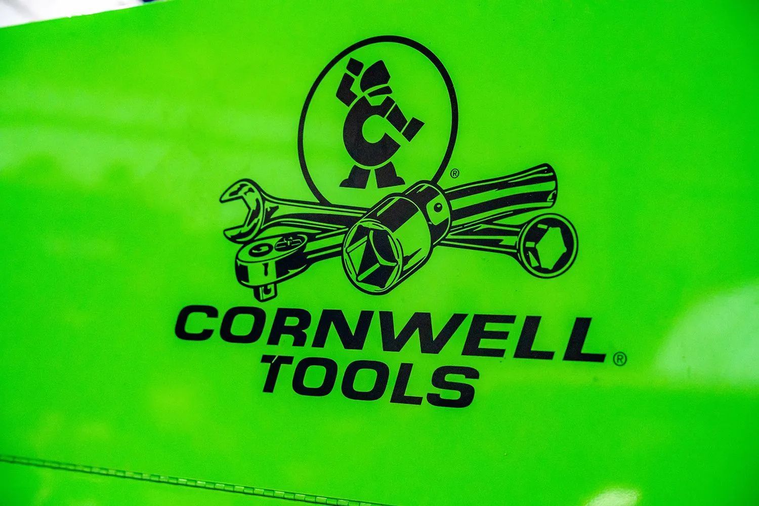 Cornwell Tools logo on bright green surface, featuring a wrench, socket, and a stylized 