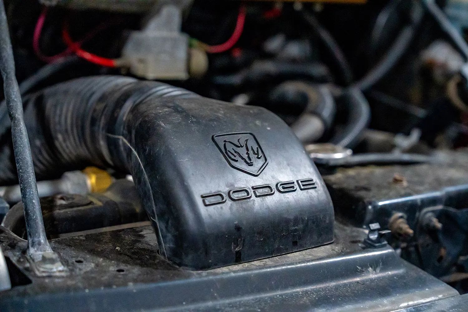 Black Dodge air intake in an engine bay.