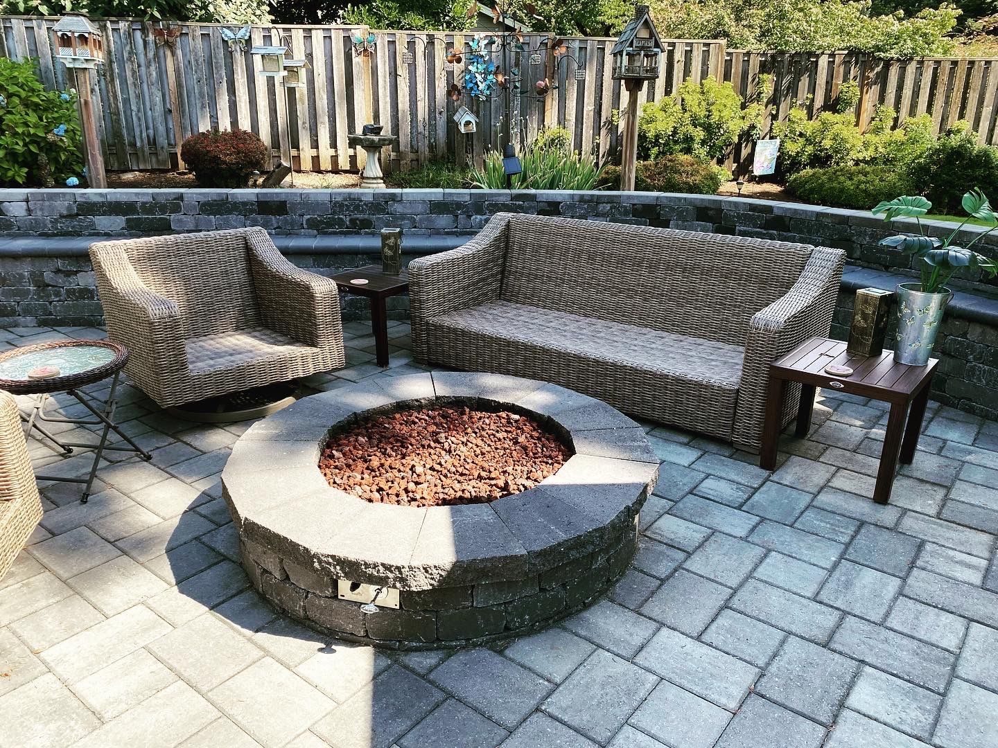 Outdoor patio with wicker furniture, fire pit, and brick pavers.