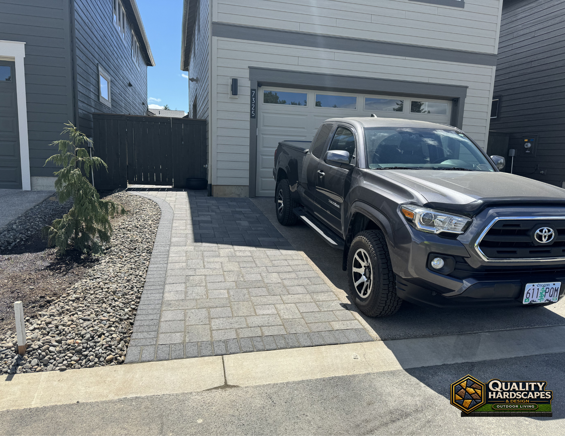 Driveway of a modern house with a black Toyota pickup truck parked in front of a garage.