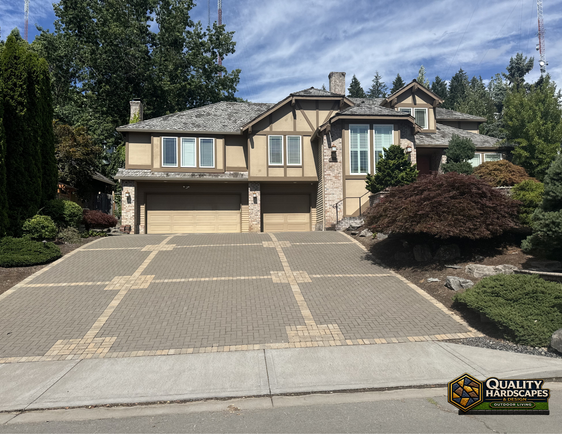 Suburban two-story house with large paved driveway, trees, and cloudy sky.