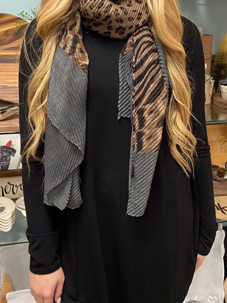A woman wearing a black dress and a leopard print scarf.