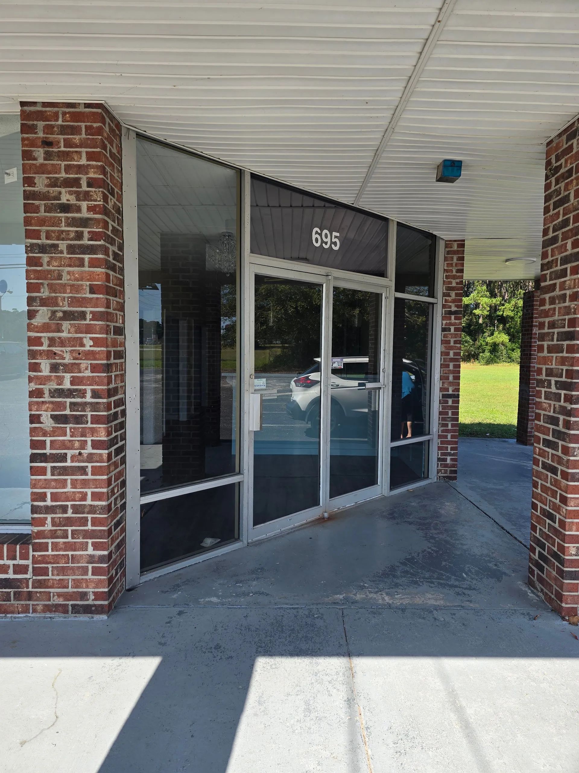Storefront with brick columns and glass windows; address 195 visible.