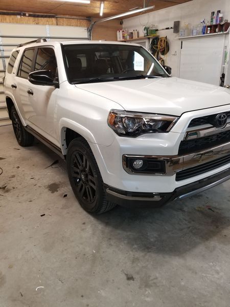 White Toyota 4Runner SUV parked in a garage with black accents.