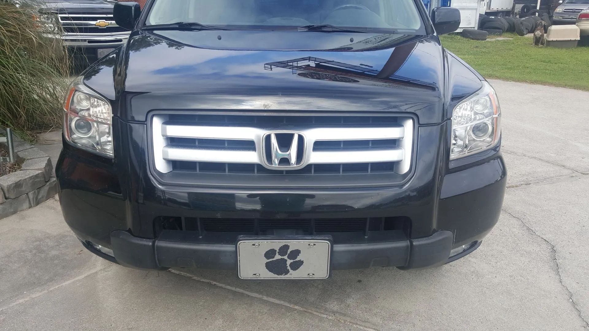 Black Honda Pilot SUV with silver grill and license plate, outdoors.
