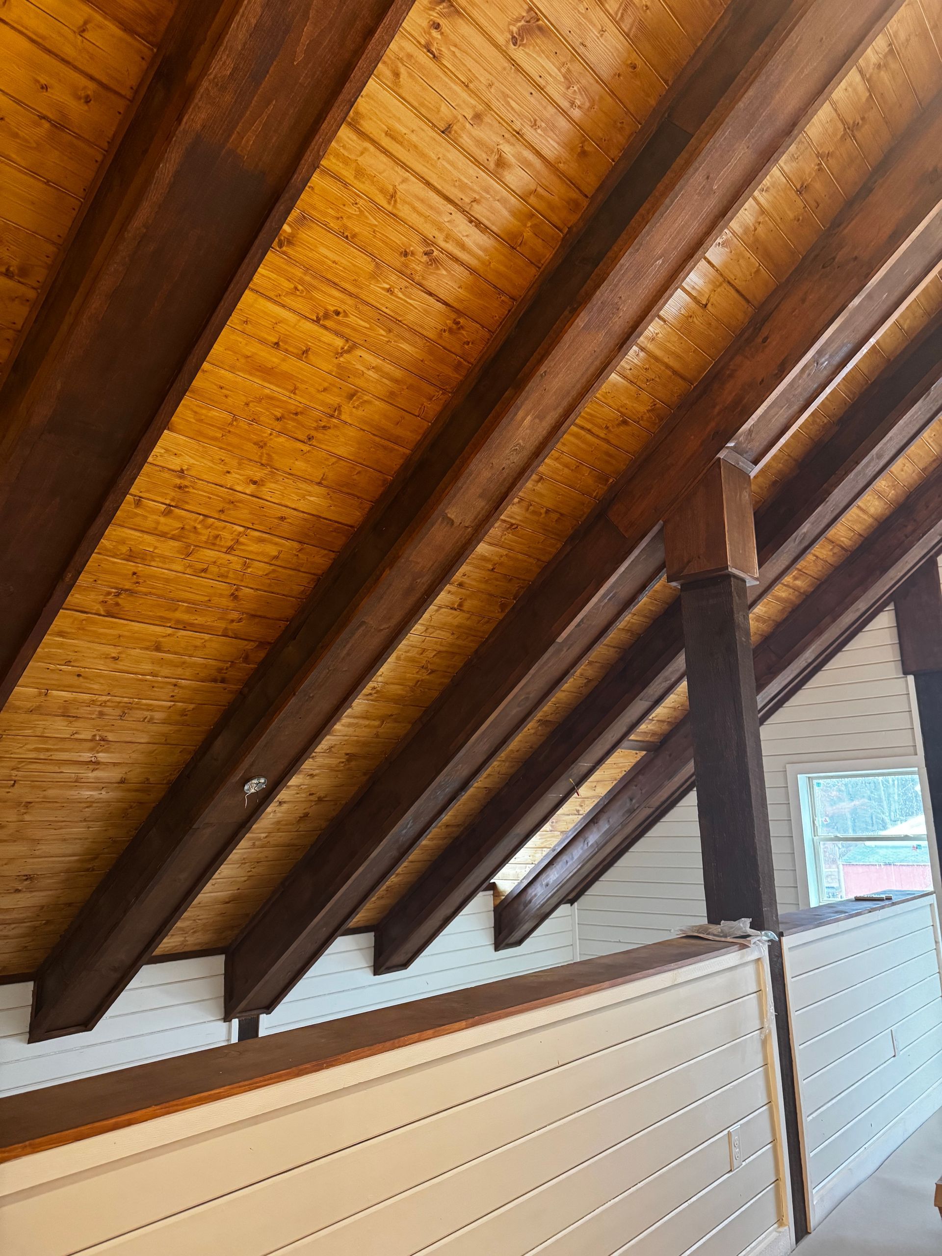 A room with a wooden ceiling and a white wall.
