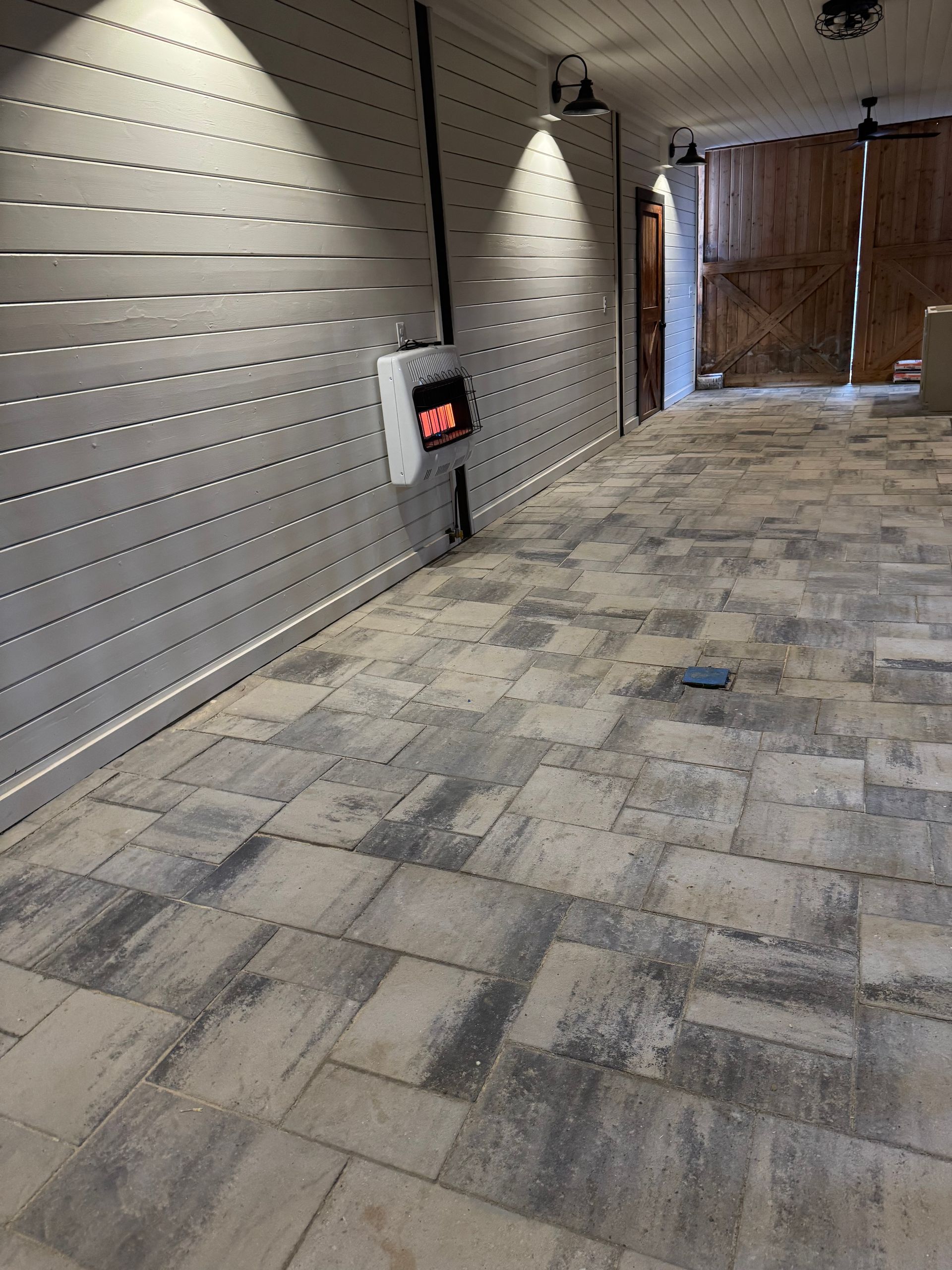 A large empty room with a tiled floor and a wooden wall.