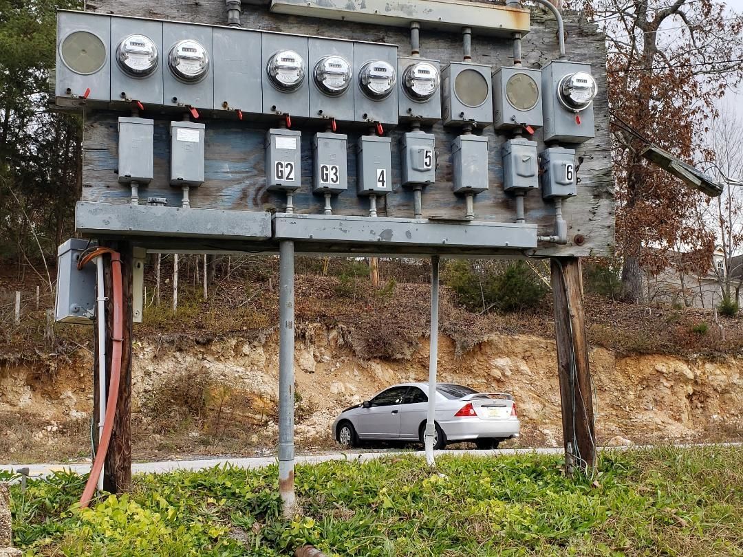 A white car is parked under a large billboard.