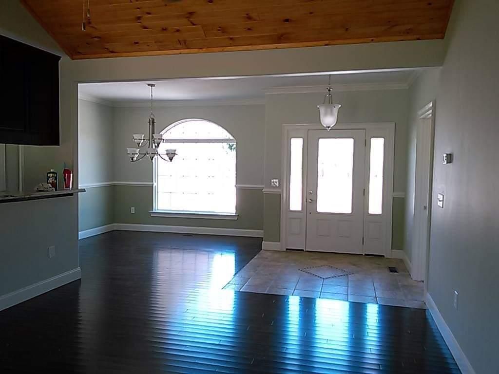 A living room with hardwood floors and a chandelier hanging from the ceiling.