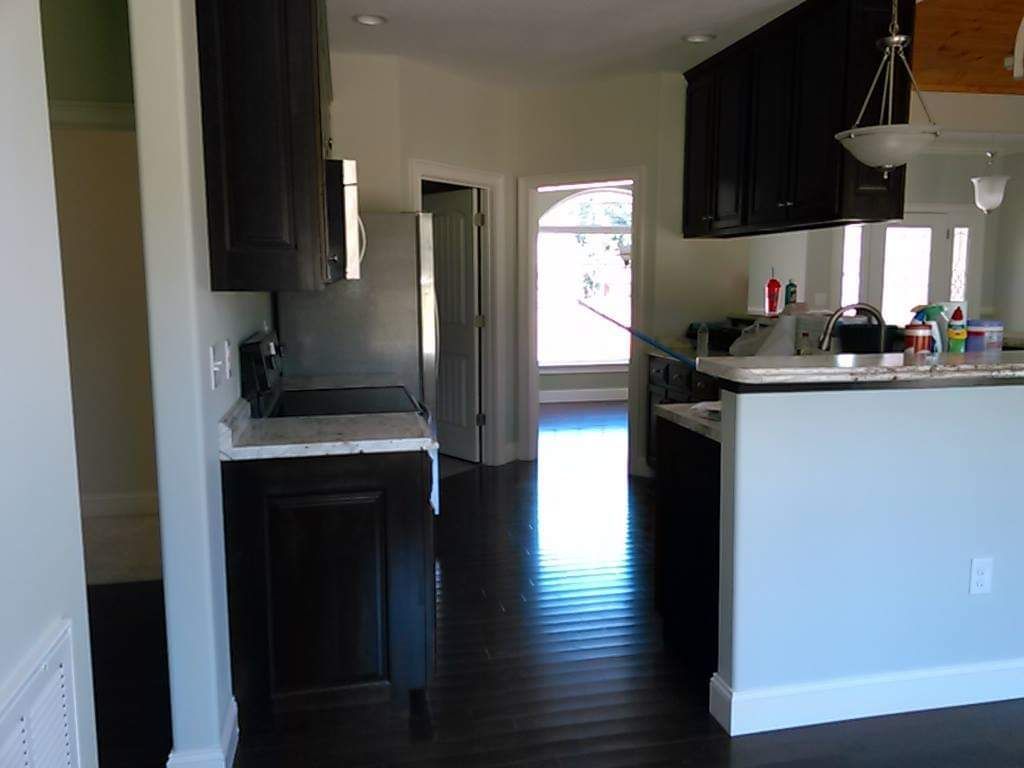 A kitchen with black cabinets and white counter tops
