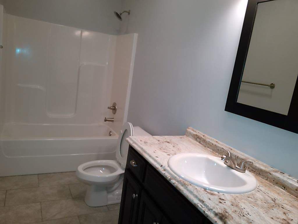 A bathroom with a toilet , sink and bathtub