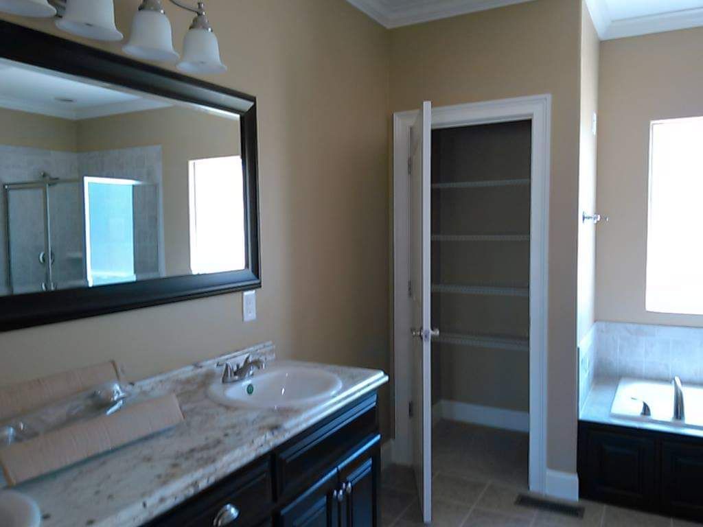 A bathroom with two sinks , a mirror and a bathtub.