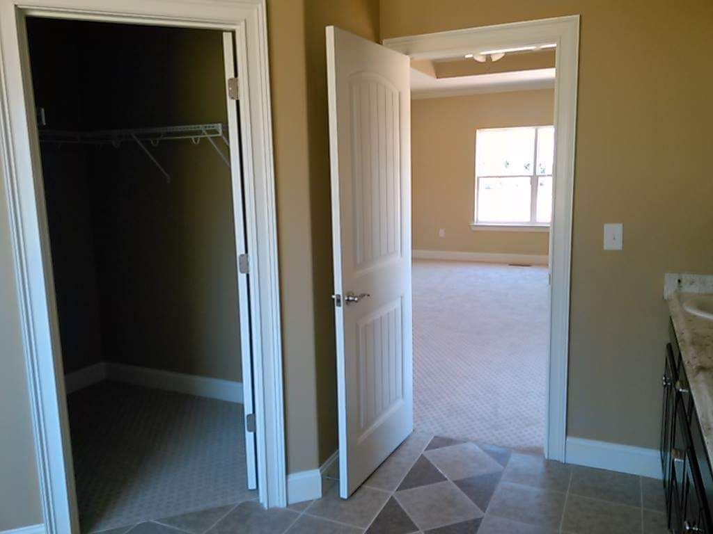A bathroom with a walk in closet and a sink