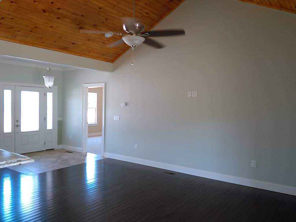 A living room with a vaulted ceiling and a ceiling fan