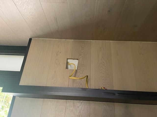 A yellow cord is plugged into a wall outlet.