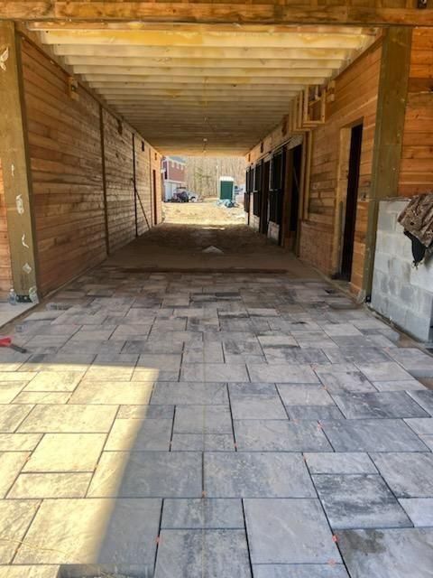 A brick walkway leading to a wooden building.