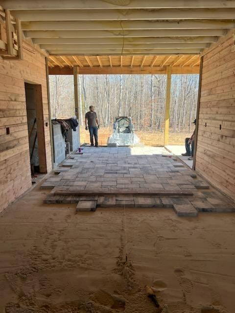 A man is standing in the middle of a room in a building under construction.