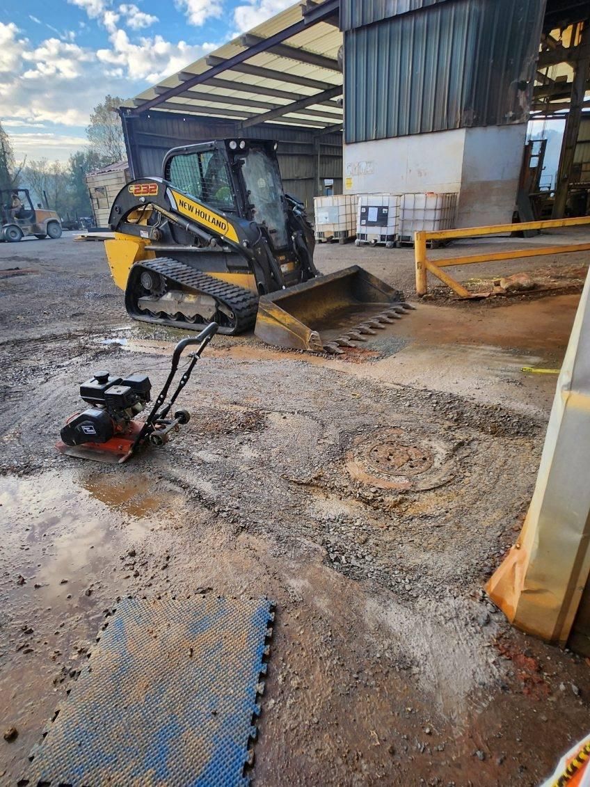 A bulldozer is parked in a dirt lot in front of a building.