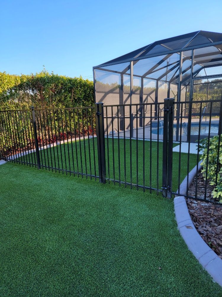 Green lawn and black fence