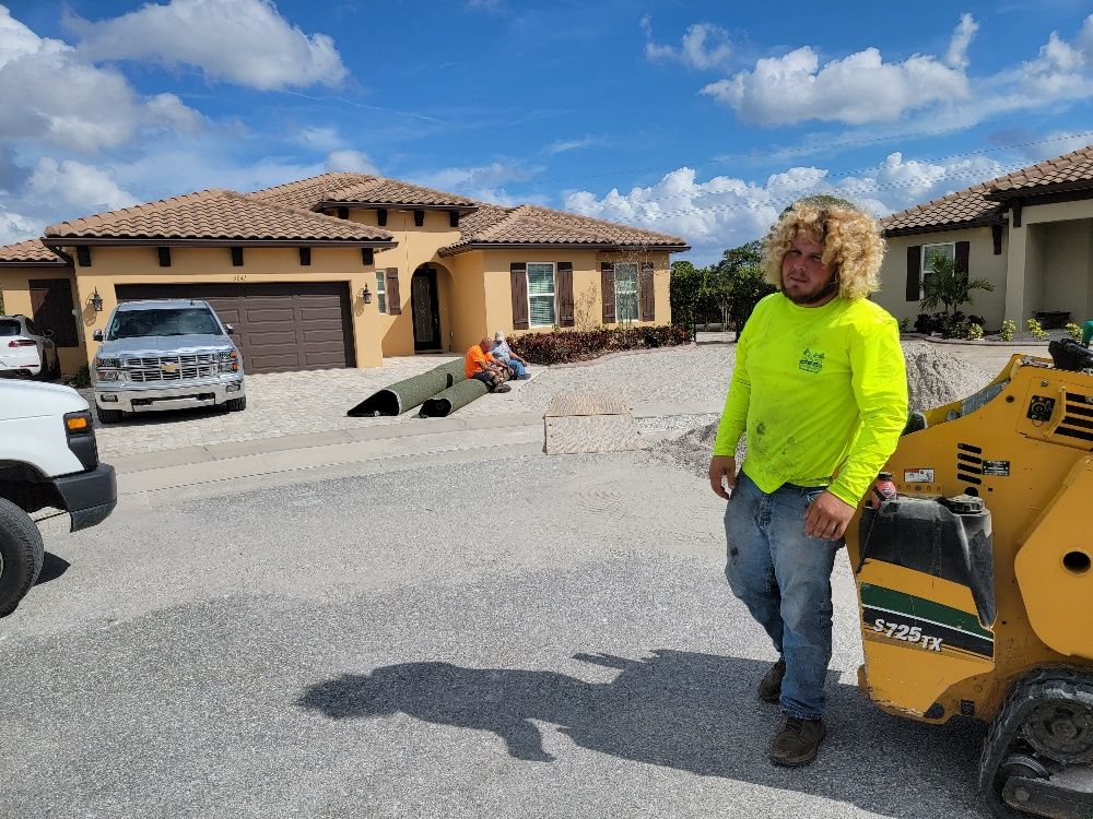 A man wearing yellow long sleeves  in front of a house