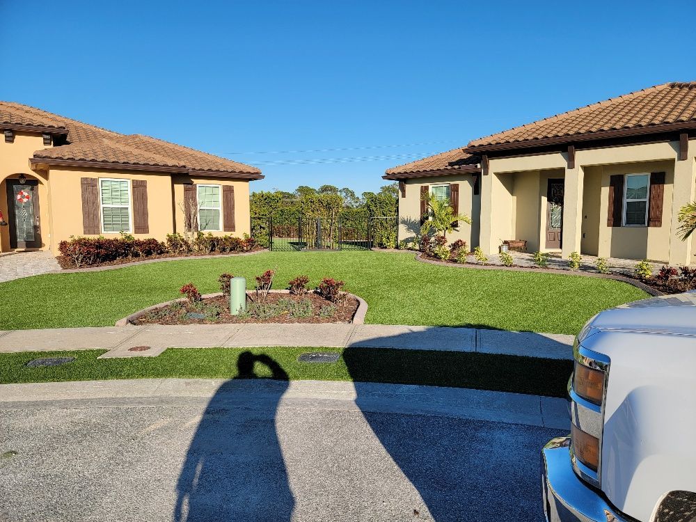 Green lawn between two houses and a man's shadow