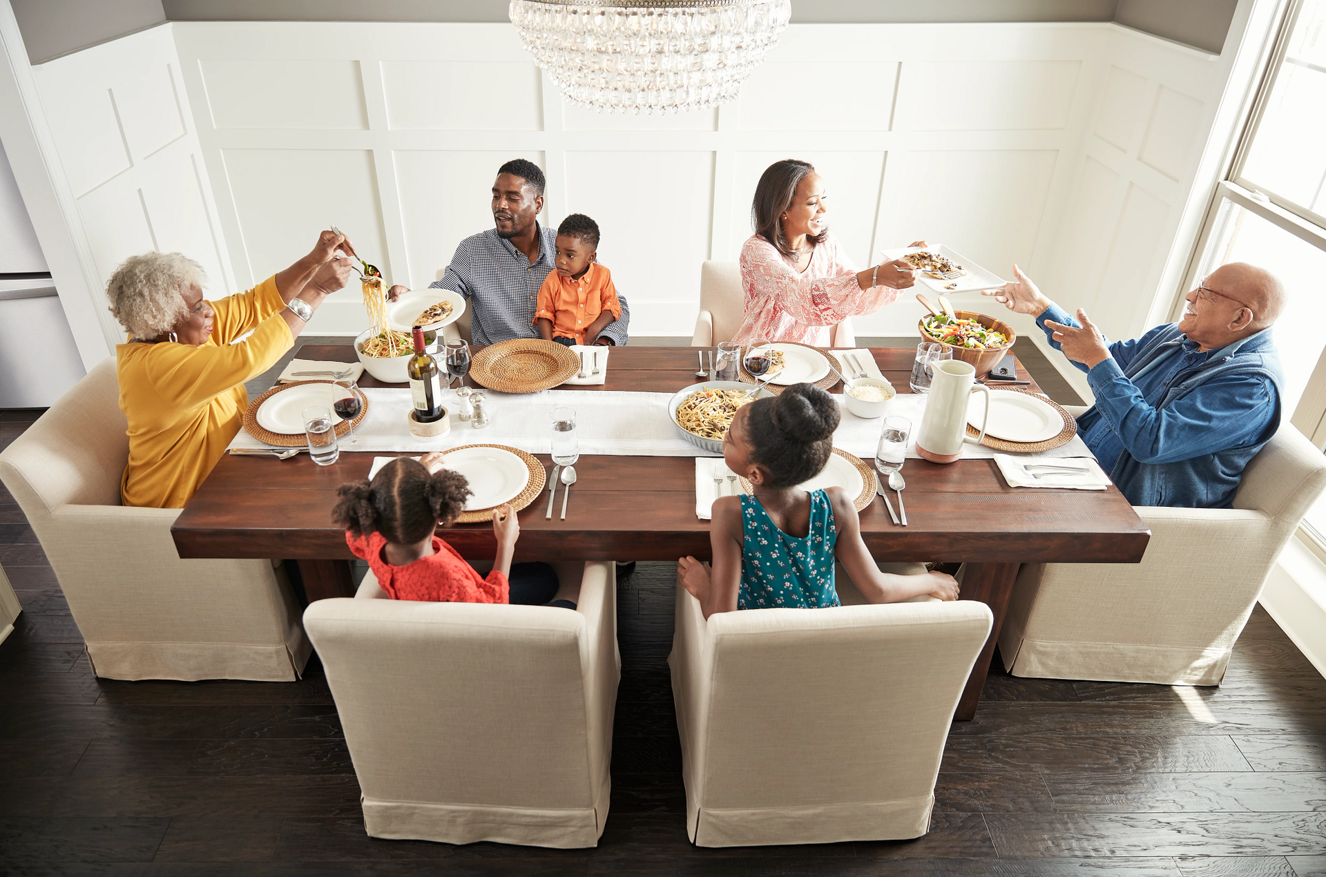 Family at a dining table, toasting with drinks.