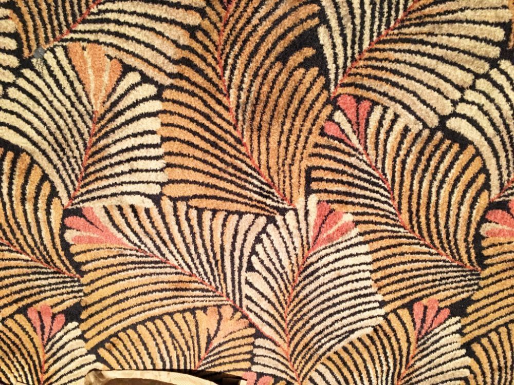 Abstract textile pattern, beige and black curved lines and pink accents.