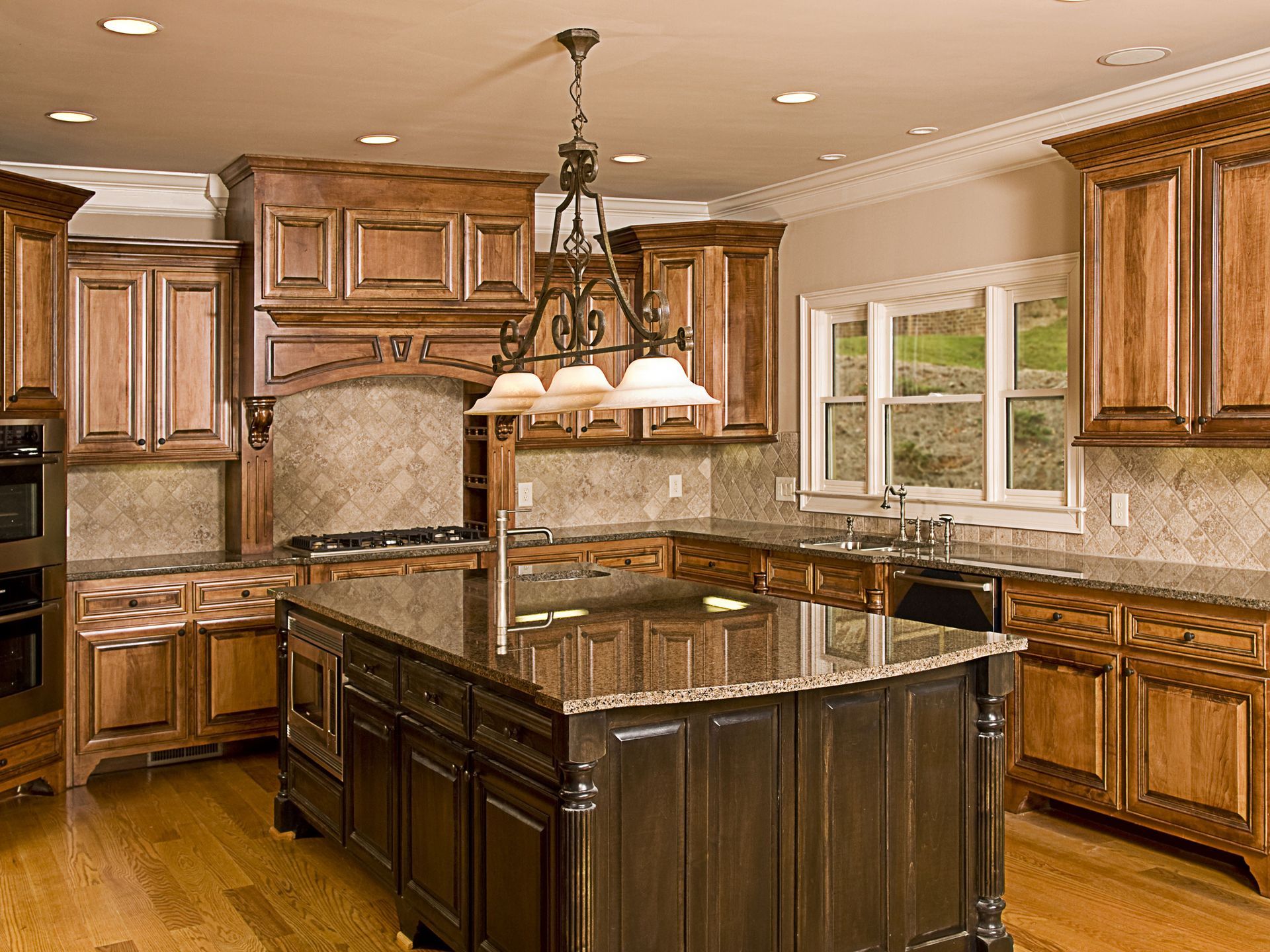 Luxurious kitchen with dark wood cabinets, granite countertops, and central island.