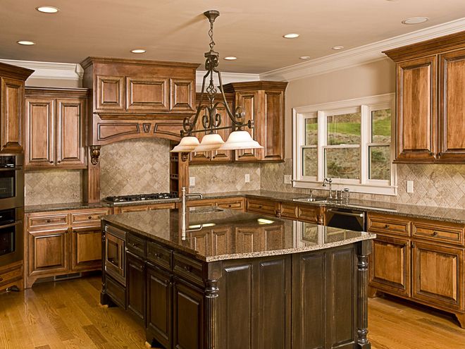 Luxurious kitchen with dark wood cabinets, granite countertops, and central island.