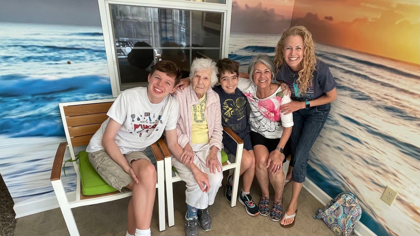 A group of people are posing for a picture in front of a beach scene.