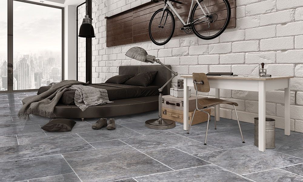 Modern loft bedroom with gray sofa bed, desk, bicycle wall decor, and large window