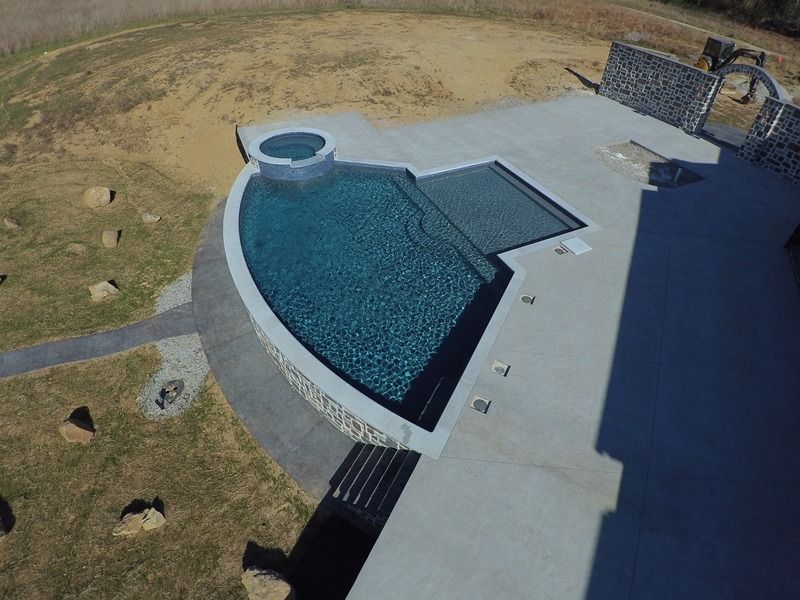 Aerial view of a custom pool and spa with stone accents on a concrete patio.