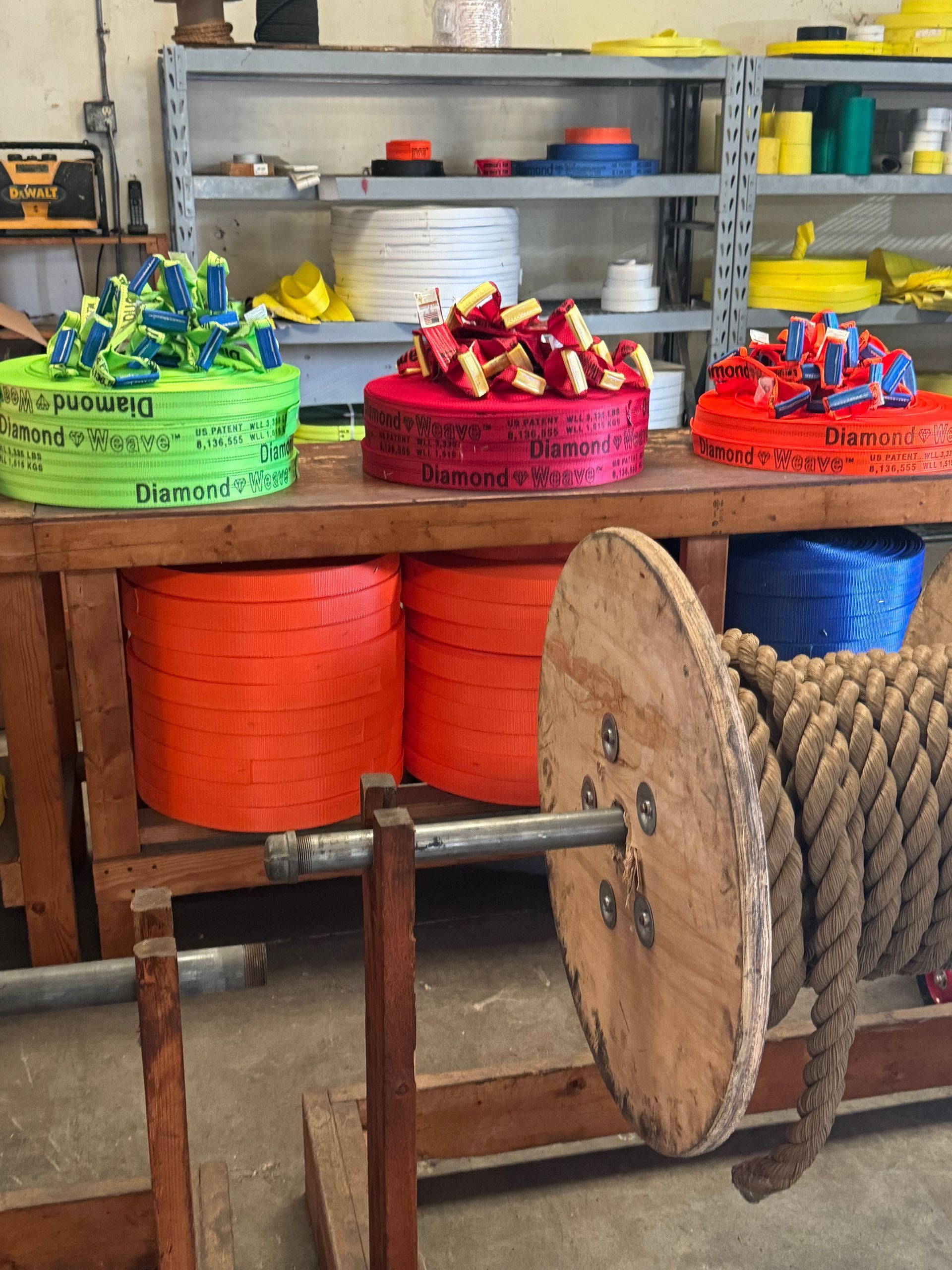 Colorful baskets of red, green, and blue thread spools on shelves in a workshop