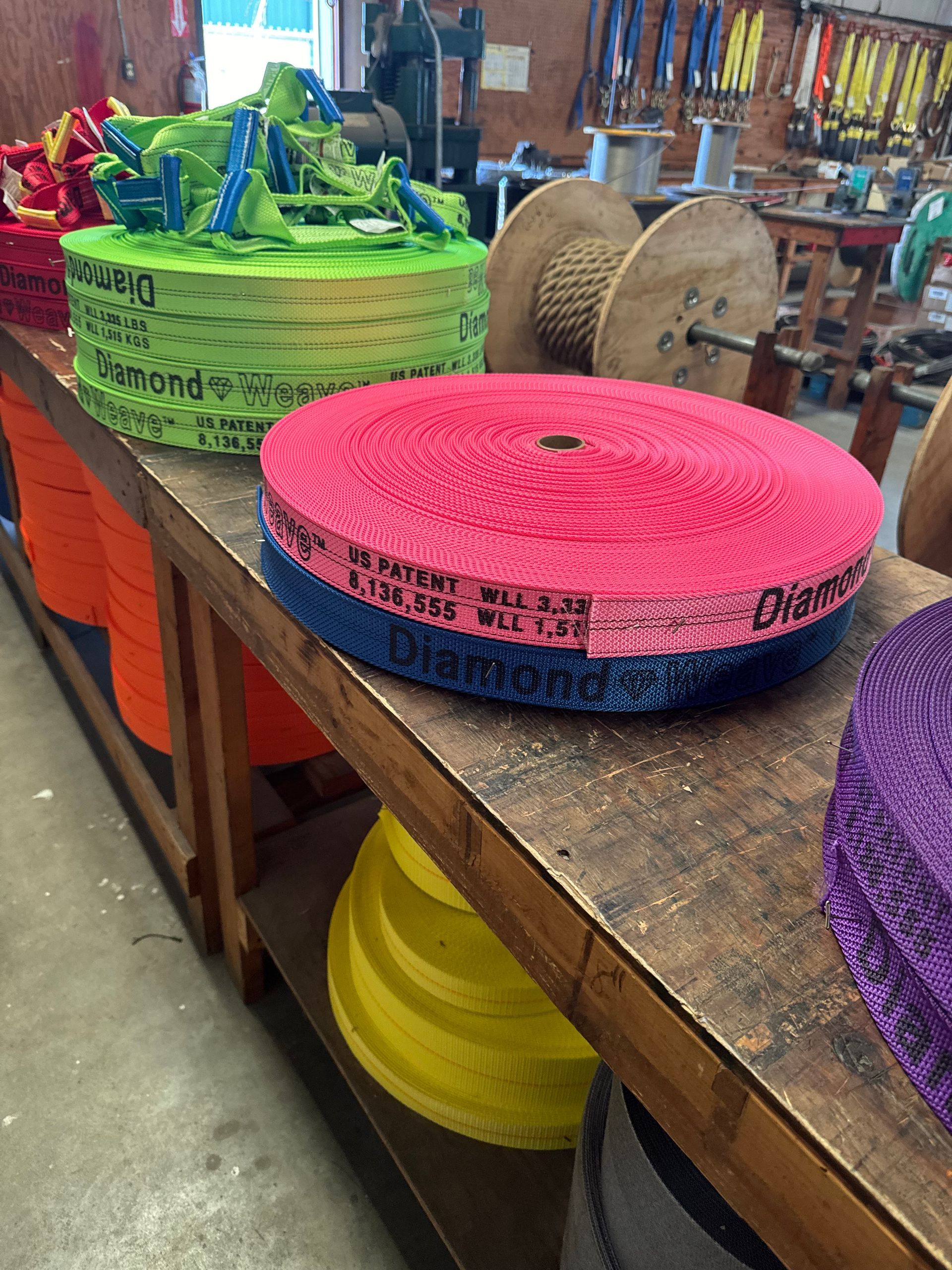 Colorful woven rolls stacked on a wooden table in a craft shop