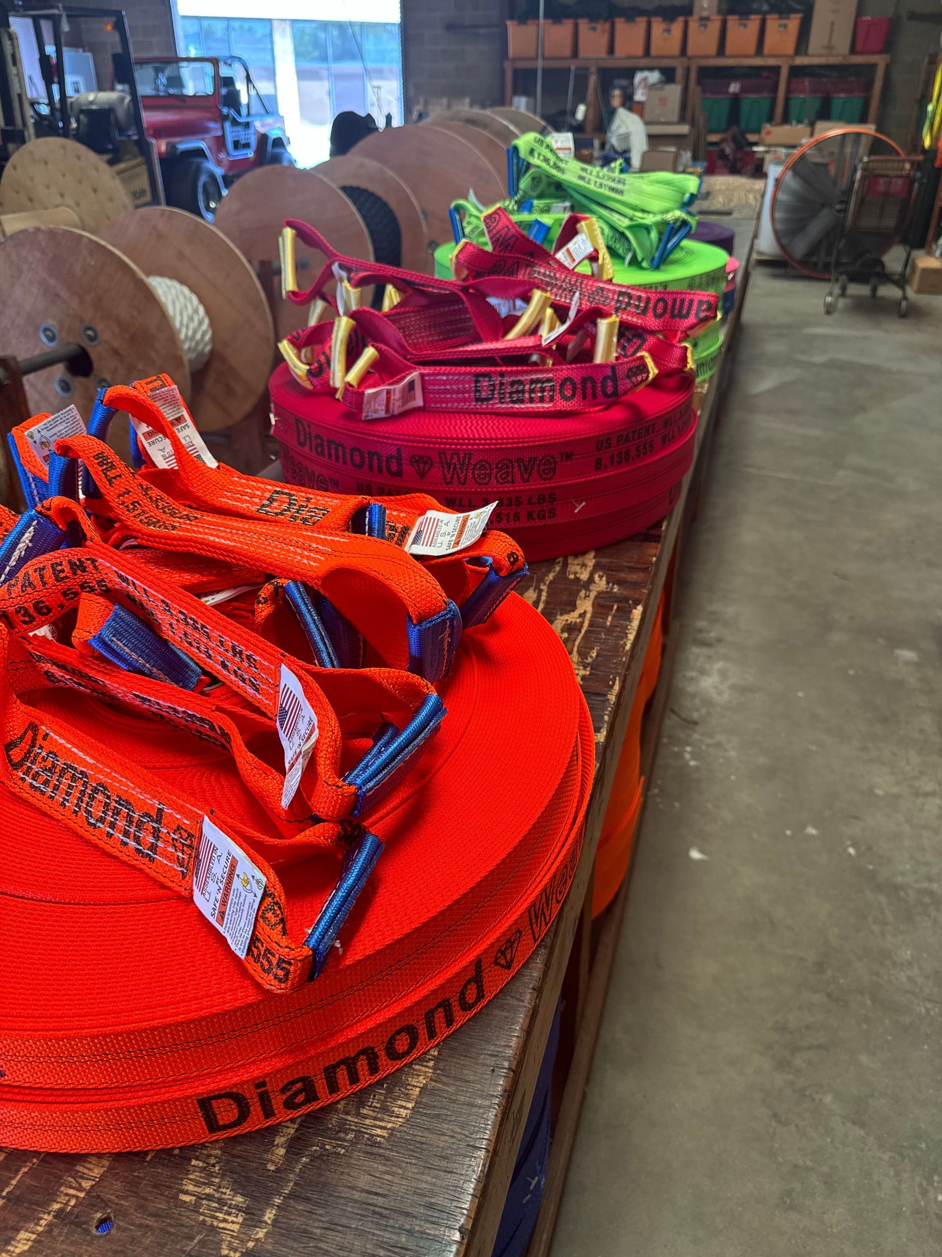 Bright woven baskets and trays in orange and pink on a wooden table in a workshop or market space