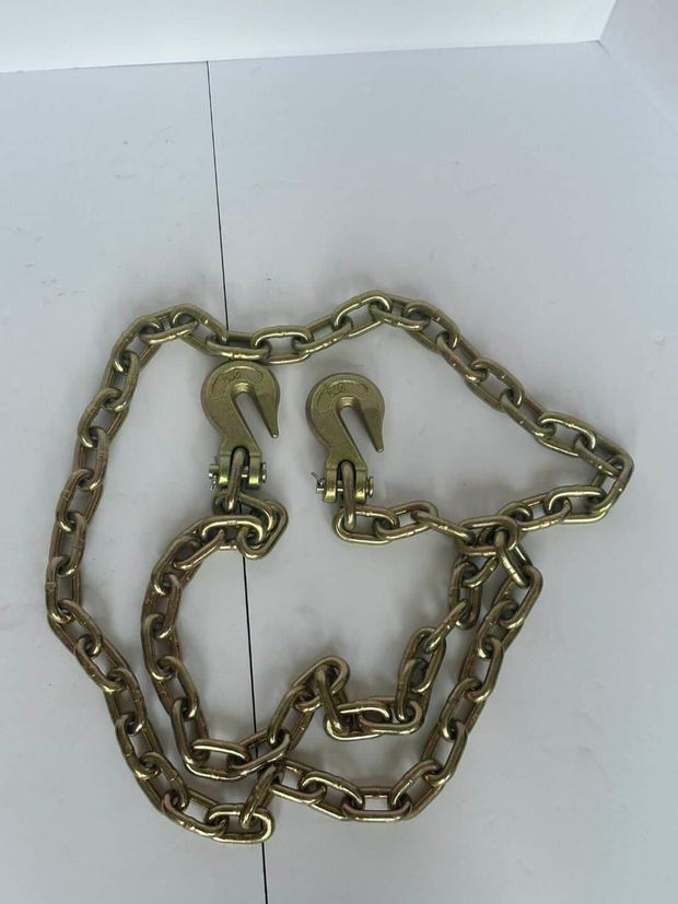 Gold chain arranged in a dog face shape on a white surface