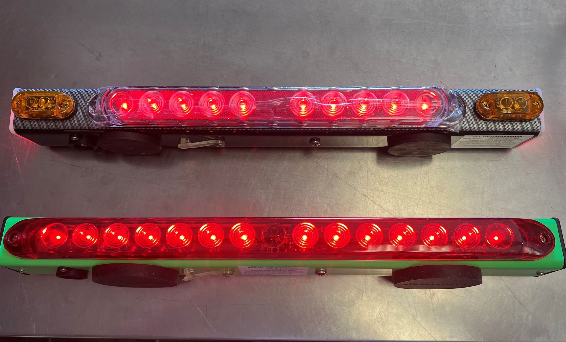 Two red emergency light bars, one above the other, lit against a light background