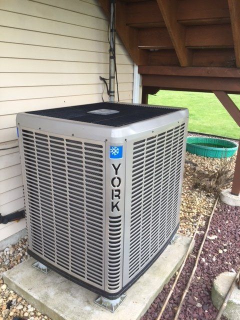 a york air conditioner is sitting outside of a house
