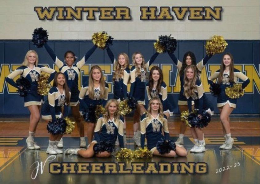 Winter Haven cheerleaders posing, blue and gold uniforms, holding pom-poms in a gymnasium.